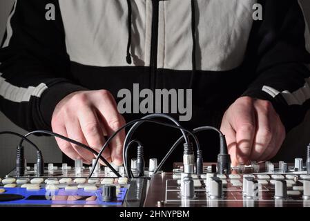 Hands at work with electronic musical instruments and synthesizers to generate and create sound for electronic music in live performance Stock Photo