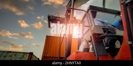 Reach stacker lifting container. Forklift truck handling container at dock. Reach stacker vehicle. Container transport in logistic industry. Cargo and Stock Photo