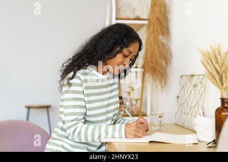 African-american female journaling in notebook. Making notes in diary. Concept of mindfulness Stock Photo