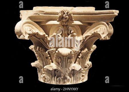 Front view of an ancient carved marble Corinthian column capital from the Villa Alba (c. 81–96), created during the reign of Emperor Domitian (51–96) in the Flavian dynasty of classical antiquity (1st century AD), featuring highly detailed acanthus leaves, stylized volutes, and a central rosette ornament isolated against a pitch black background. Stock Photo