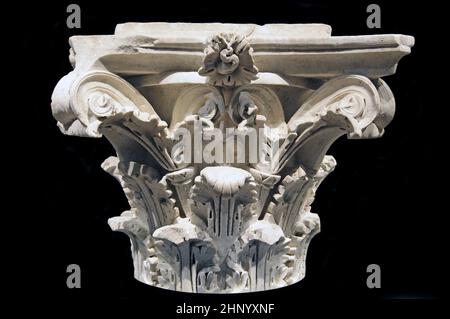 Front view of an ancient carved marble Corinthian column capital from the Villa Alba (c. 81–96), created during the reign of Emperor Domitian (51–96) in the Flavian dynasty of classical antiquity (1st century AD), featuring highly detailed acanthus leaves, stylized volutes, and a central rosette ornament isolated against a pitch black background. Stock Photo