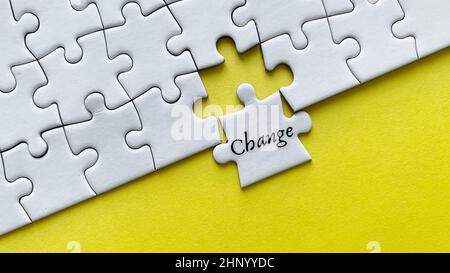 Top view of text - Change. On yellow background of white jigsaw. Stock Photo