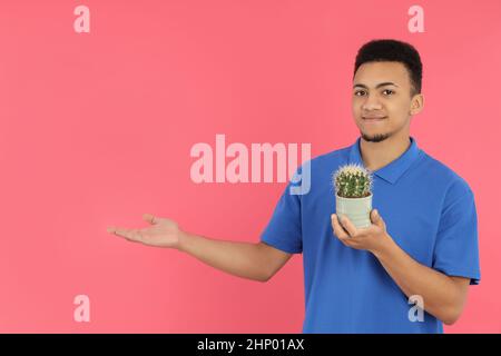 Young man with cactus on pink background Stock Photo