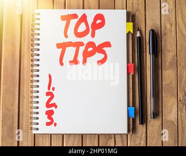 Writing displaying text Top Tips, Word Written on small but particularly useful piece of practical advice Blank Open Spiral Notebook With Diffrent Pen Stock Photo