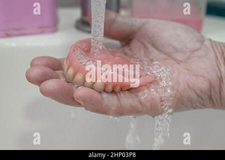 Asian senior or elderly old woman patient holding partial denture of replacement teeth. Stock Photo