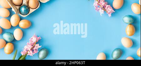 Easter eggs, flowers on blue background. Flat lay, top view, copy space. Easter day. Stock Photo