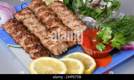 Lula kebab in Mediterranean cuisine with fresh herbs Stock Photo