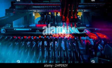 Automated production of computer system boards by Pick and Place robot. Robot Manipulators for assembling computer chips and system computer boards place electronic components on board for fixing. Stock Photo