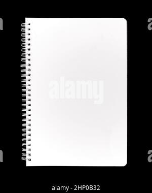 A closed notebook, with a blank empty white cover, isolated on a black background. Stock Photo