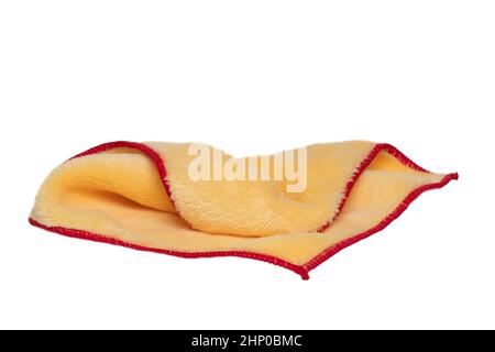 Household cleanliness and hygiene. Close-up of a yellow cleaning cloth isolated on a white background. Microfiber cleaning cloth. Macro. Stock Photo