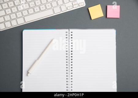 Keyboard Over A Table Beside A Notebook And Pens With Sticky Notes Stock Photo