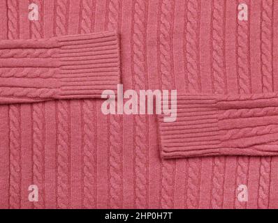 Close up background texture of pink cable knitted wool jersey fabric sweater with row braid pattern Stock Photo