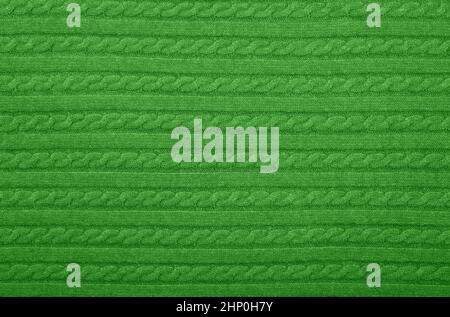 Close up background texture of green cable knitted wool jersey fabric sweater with row braid pattern Stock Photo