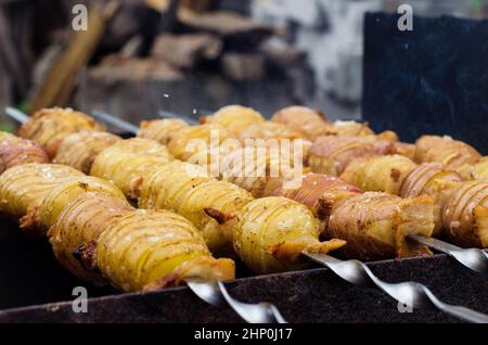 Potato with bacon on skewers cooked at the stake Stock Photo