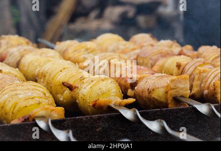 Potato with bacon on skewers cooked at the stake Stock Photo