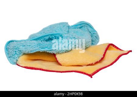 Household cleanliness and hygiene. Close-up of a blue and a yellow cleaning cloth isolated on a white background. Microfiber cleaning cloth. Macro. Stock Photo