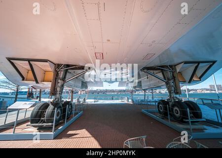 View from below of the BAC Aérospatiale Concorde exhibit on the Hudson River with the picnic area of the Intrepid Museum, New York, NY, USA underneath Stock Photo