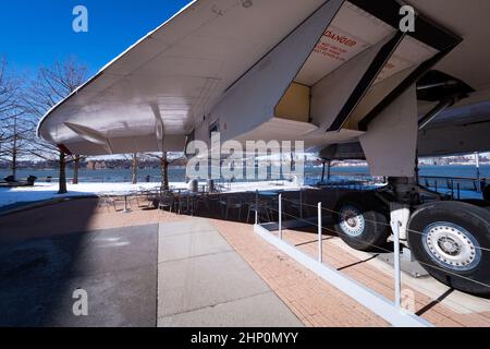 View from below of the BAC Aérospatiale Concorde exhibit on the Hudson River with the picnic area of the Intrepid Museum, New York, NY, USA underneath Stock Photo