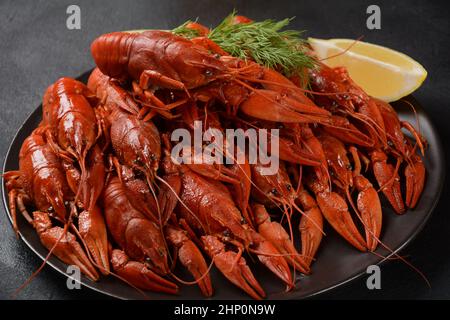 Red boiled crawfishes on table in rustic style. Asian Chinese Food Spicy Crayfish Stock Photo