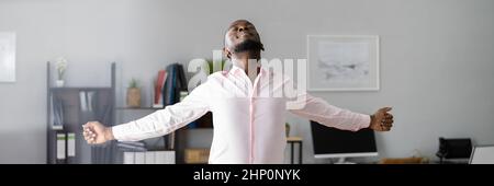 Man Doing Stretch Exercise At Work In Office Stock Photo