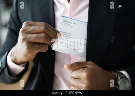 Holding Paycheck Or Payroll Check Or Insurance Cheque In Hand Stock Photo
