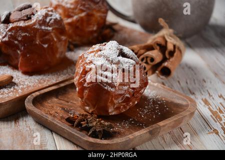 Baked apples with nuts and raisins. Homemade baked apples in the oven, with sugar powder close-up. Holiday dessert Stock Photo