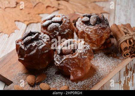 Baked apples with nuts and raisins. Homemade baked apples in the oven, with sugar powder close-up. Holiday dessert Stock Photo