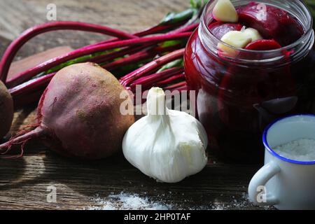 Pickled beets in the jar on a dark wood background . Stock Photo