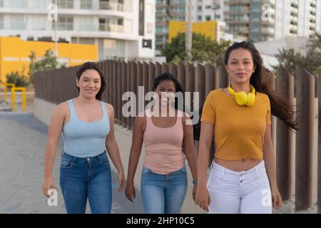 Portrait of happy young friends walking in the park. Femininity Concept. Stock Photo