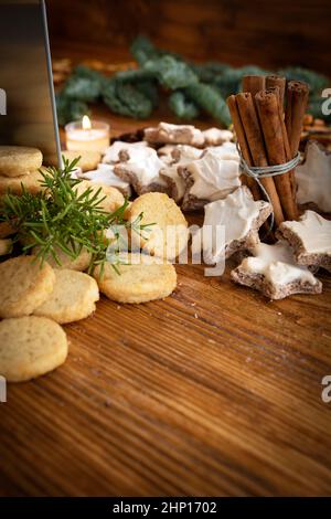 Different homemade christmas cookies with spices on vintage wood. Vertical background with short depth of field for the sweet christmas baking. Stock Photo