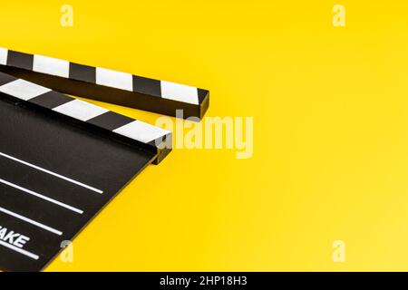 Black clapper board on yellow background Stock Photo - Alamy