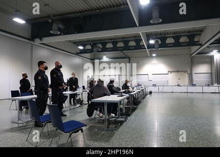 Bremen, Germany. 18th Feb, 2022. Defendants, defense attorneys and court officials stand and sit in an exhibition hall that serves as a courtroom during the trial at the Bremen Regional Court. The trial is about trafficking in cocaine, heroin and marijuana worth almost three million euros. (To dpa: '15th Encrochat trial in Bremen: drugs for three million euros') Credit: Friedemann Kohler/dpa/Alamy Live News Stock Photo