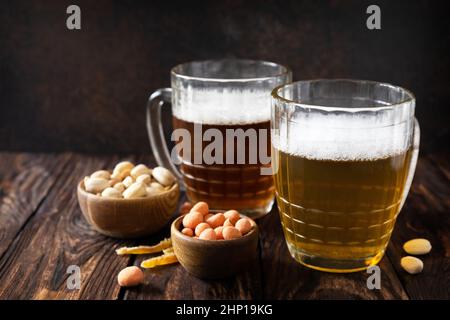 Alcohol drinkpint of lager and pint of stout, craft beer. Two Glass of Beer with foam and snacks on a wooden rustic background. Traditional German whe Stock Photo