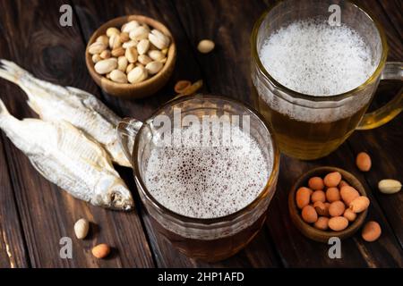 Alcohol drinkpint of lager and pint of stout, craft beer. Two Glass of Beer with foam and snacks on a wooden rustic background. Traditional German whe Stock Photo