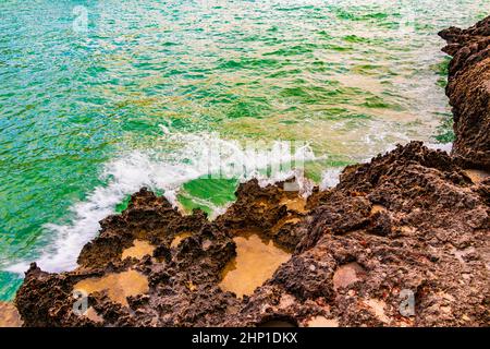 Rocks cliffs caves and huge stones in the turquoise water on Mallorca in Spain. Stock Photo