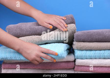 A studio concept photo of female hands reaching for a folded towel. Stock Photo