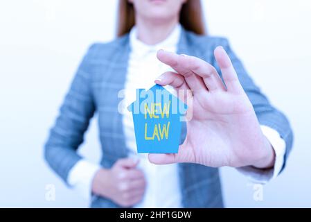 Text caption presenting New Law, Business concept system of rules that enforced through social or governmental A Young Lady Businesswoman Holding Pres Stock Photo