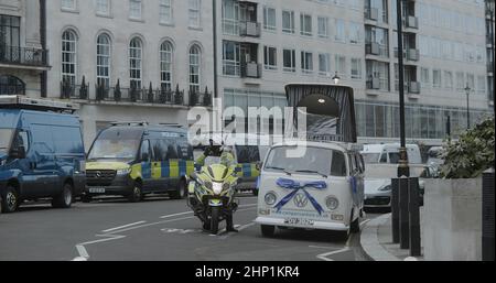 London, UK - 01 22 2022:  Metropolitan police officer on a motorbike with police vans parked on the road at Portland Place. Stock Photo