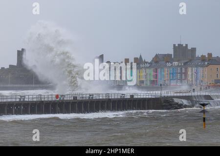 Aberystwyth, UK. 18th Feb, 2022. 18 February 2022, Aberystwyth, Wales, UK. Storm Eunice. Gale force winds cause very rough seas at high tide on the mid Wales coast. Huge waves pummel the the promenade and sea defences at the mouth of Aberystwyth harbour. Credit: atgof.co/Alamy Live News