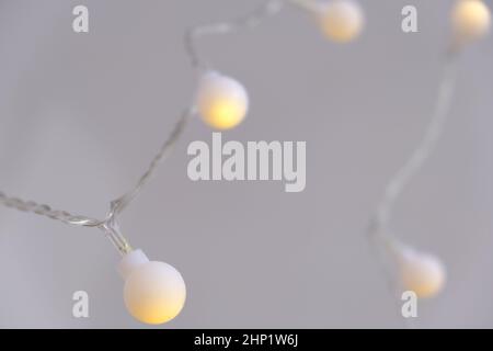 Close-up light chain decoration, festive lights garland, light bulbs on string wire, selective focus Stock Photo