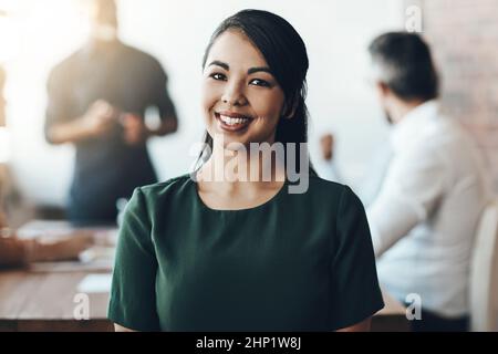 She puts in the work. Cropped portrait of a young businesswoman sitting in the boardroom during a presentation. Stock Photo