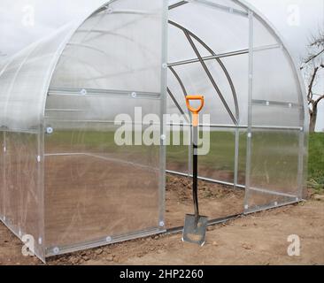 Greenhouse in back garden ready for planting vegetables . Stock Photo