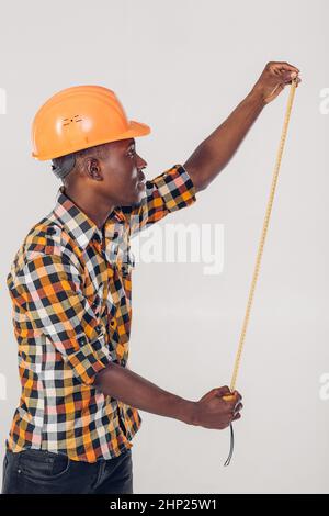 African American worker builder uses a measuring tape Stock Photo