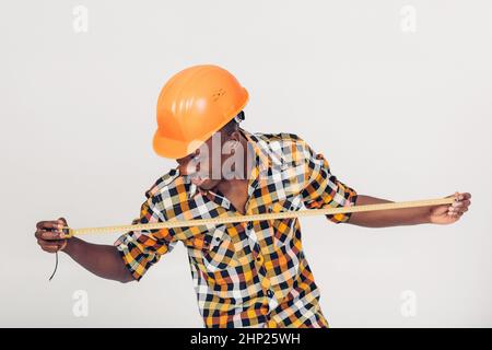 African American worker builder uses a measuring tape Stock Photo
