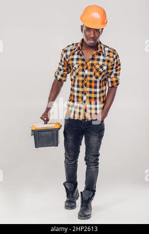 African American construction worker in helmet with yellow plastic tool box Stock Photo