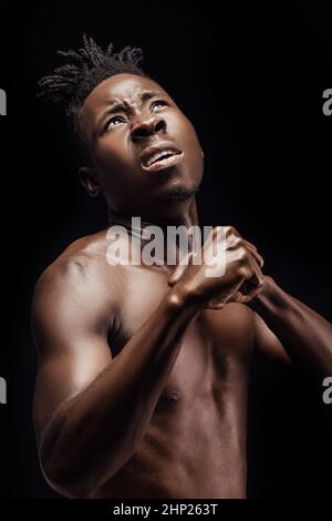 African-American athlete waiting for an opponent to strike on black background Stock Photo