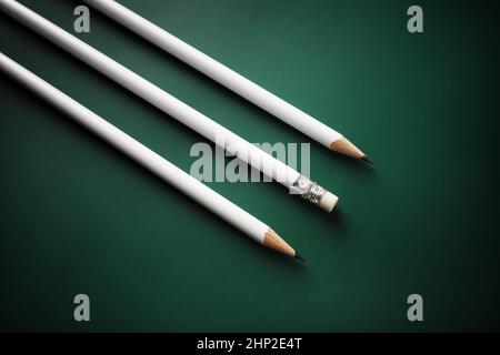 Three blank white pencils on green background. Stock Photo