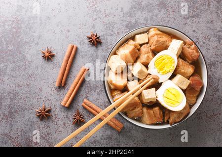 Kai Palo popular Thai cuisine has an easy menu serving hard boiled egg and pork belly and Tofu over soy broth closeup in the bowl on the table. Horizo Stock Photo