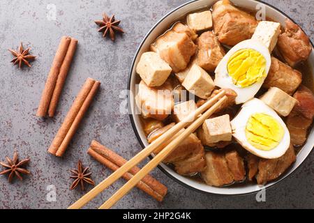 Kai Pa Lo Thai Stewed Pork Belly with Eggs and Tofu closeup in the bowl on the table. Horizontal top view from above Stock Photo