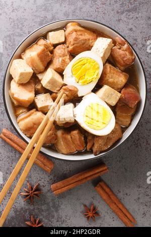 Five Spice Egg and Pork Belly Stew Asian food closeup in the bowl on the table. Vertical top view from above Stock Photo